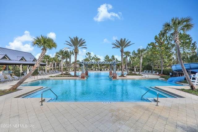 pool with a water slide, a patio, and a pergola