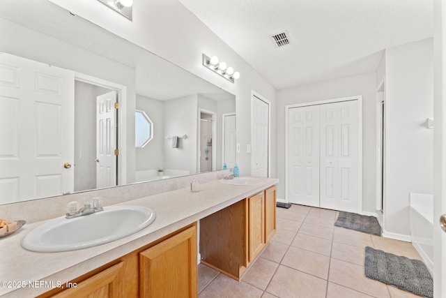 bathroom with double vanity, a stall shower, tile patterned flooring, and a sink