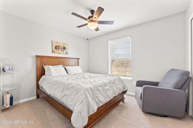 bedroom with light carpet, ceiling fan, baseboards, and a textured ceiling