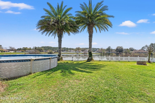 view of yard featuring a fenced in pool, a water view, and fence