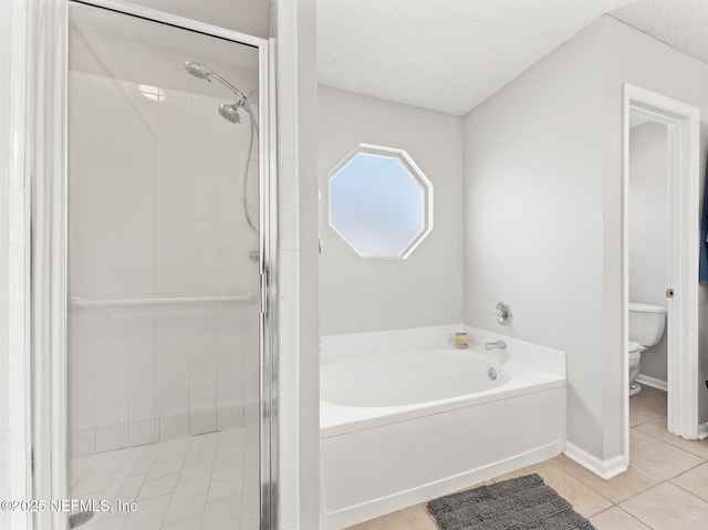 full bath featuring a garden tub, toilet, a shower stall, a textured ceiling, and tile patterned flooring