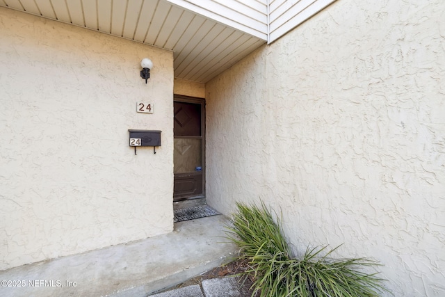 entrance to property with stucco siding