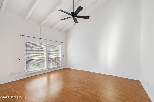 spare room with baseboards, ceiling fan, beamed ceiling, wood finished floors, and high vaulted ceiling