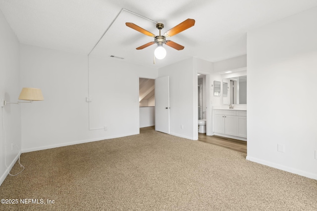 unfurnished bedroom featuring visible vents, carpet flooring, ensuite bath, and baseboards