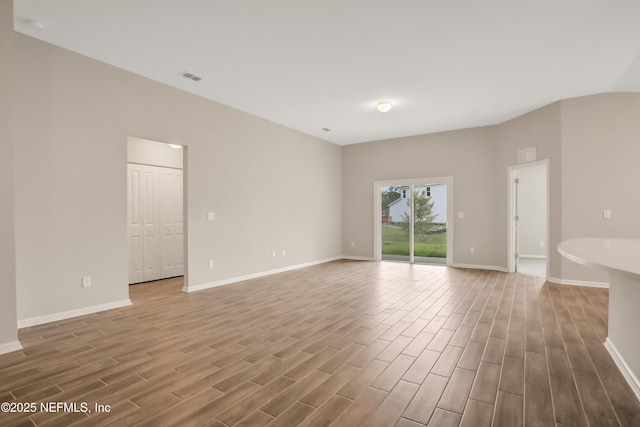 unfurnished room featuring visible vents, baseboards, and wood finish floors