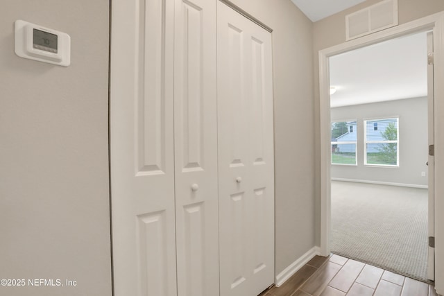 hallway featuring baseboards, wood tiled floor, and visible vents