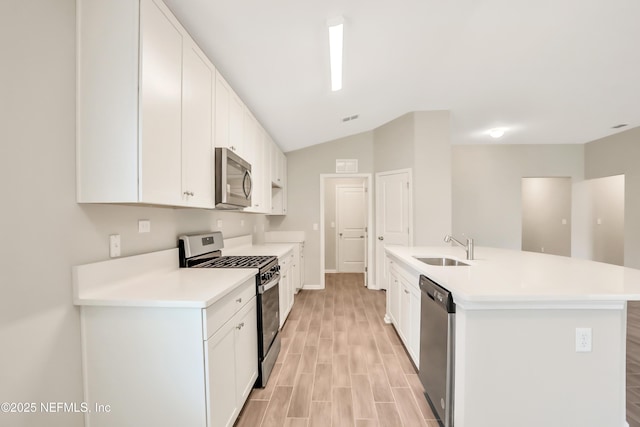 kitchen with appliances with stainless steel finishes, light countertops, white cabinets, and a sink