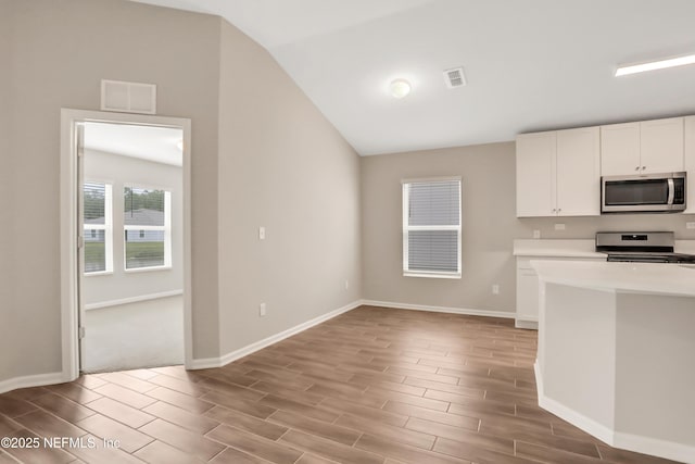 kitchen with stainless steel appliances, wood finish floors, visible vents, white cabinetry, and light countertops