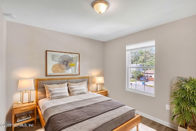 bedroom with baseboards and wood finished floors