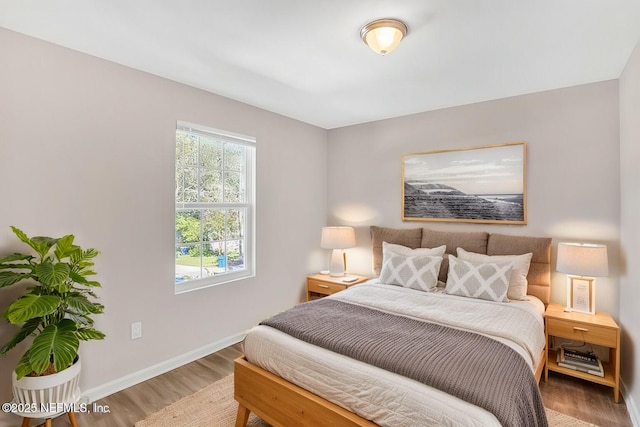 bedroom with wood finished floors and baseboards