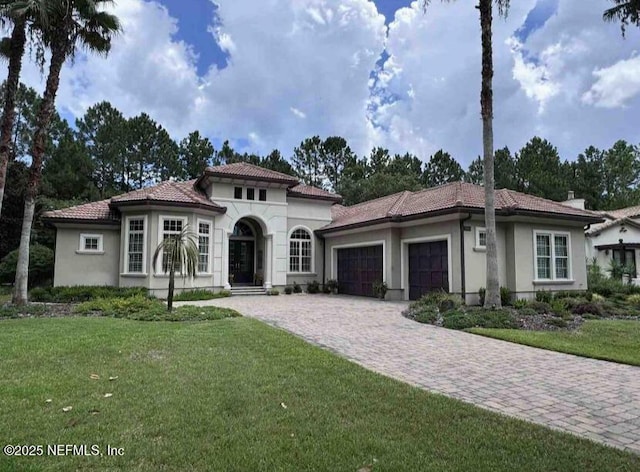 mediterranean / spanish home featuring a garage, a tiled roof, and stucco siding