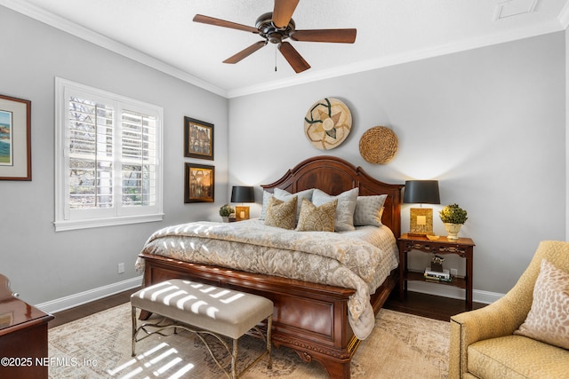 bedroom featuring crown molding, visible vents, ceiling fan, wood finished floors, and baseboards