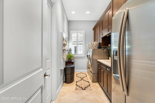 clothes washing area with separate washer and dryer, recessed lighting, and baseboards