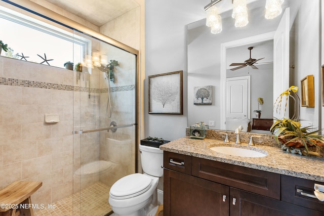 full bathroom with vanity, a shower stall, toilet, and a ceiling fan