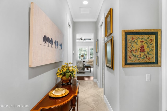 hallway featuring light tile patterned floors, ornamental molding, and baseboards