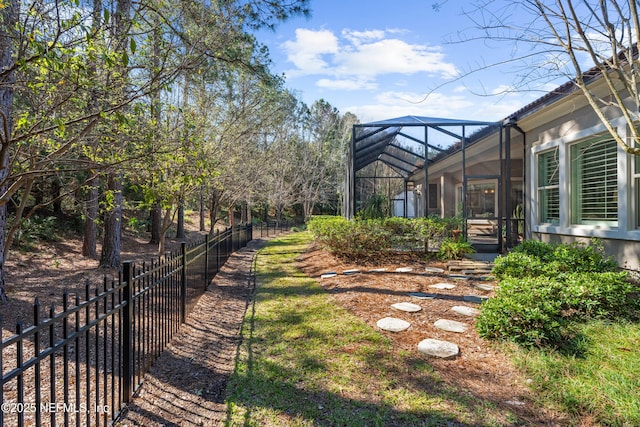 view of yard with glass enclosure and fence