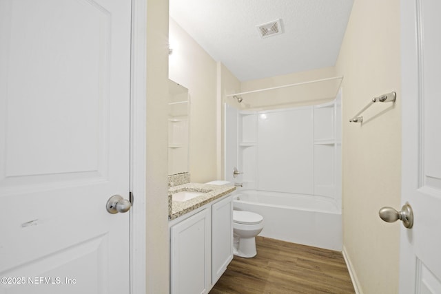 bathroom featuring visible vents, toilet, vanity, a textured ceiling, and wood finished floors