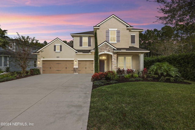 traditional-style house with a yard, stucco siding, concrete driveway, an attached garage, and stone siding