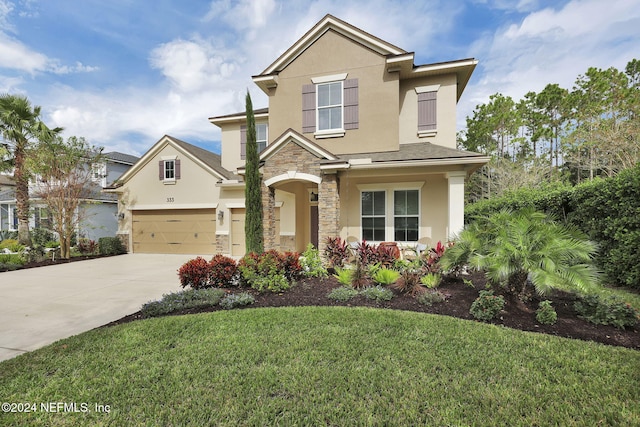 view of front of home with a garage, concrete driveway, stone siding, stucco siding, and a front yard