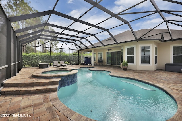 view of swimming pool featuring ceiling fan, a patio, a lanai, and a pool with connected hot tub