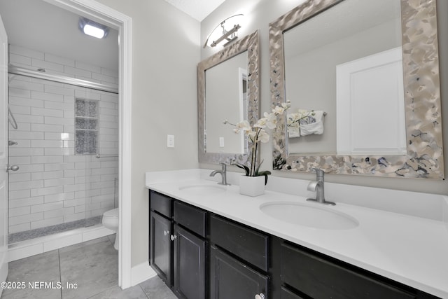 bathroom with toilet, tile patterned flooring, a shower stall, and a sink