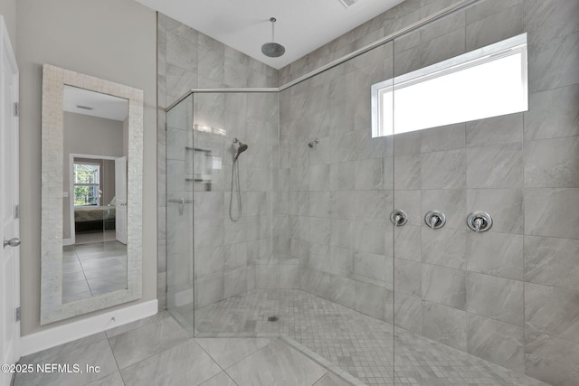 bathroom with tile patterned flooring, connected bathroom, and a tile shower