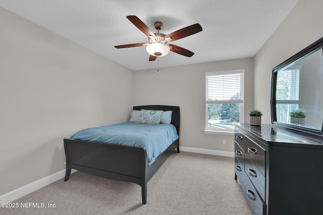 bedroom with light colored carpet, ceiling fan, a textured ceiling, and baseboards