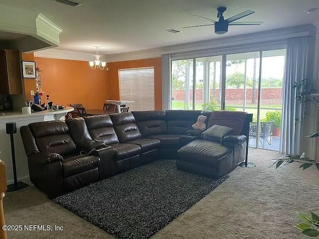 living area with ceiling fan with notable chandelier, ornamental molding, and visible vents