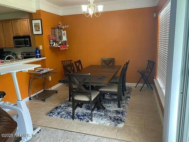 dining area with baseboards, crown molding, an inviting chandelier, and light tile patterned floors