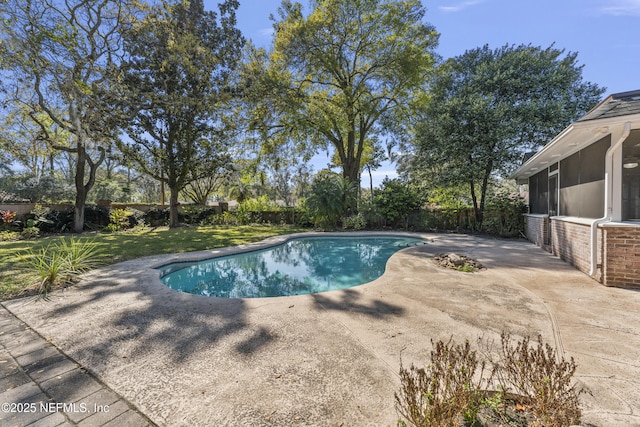 outdoor pool featuring a sunroom, a fenced backyard, a patio, and a lawn