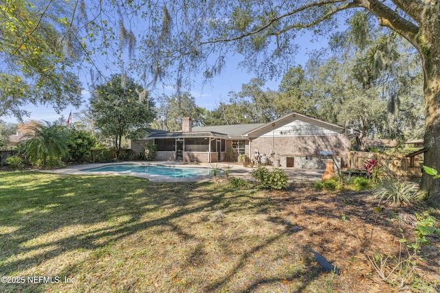 back of house featuring a fenced in pool, a lawn, a sunroom, a fenced backyard, and a chimney