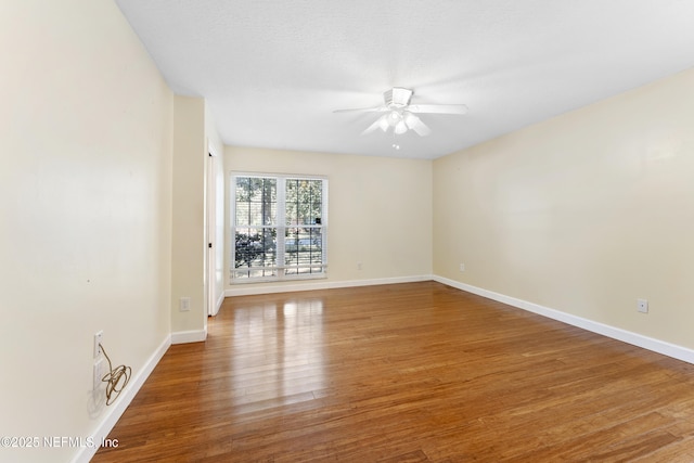 spare room with a ceiling fan, a textured ceiling, baseboards, and wood finished floors