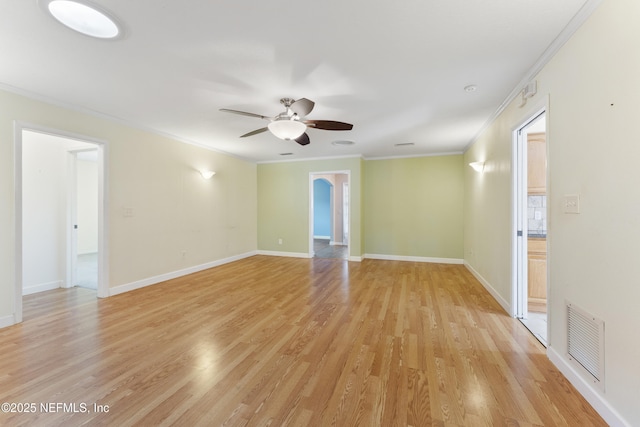 unfurnished room featuring light wood-style flooring, visible vents, baseboards, and ornamental molding