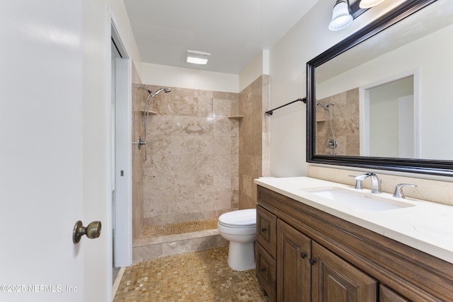 full bath featuring toilet, tiled shower, and vanity