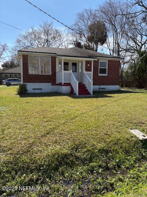 view of front of property featuring a front yard, crawl space, and brick siding