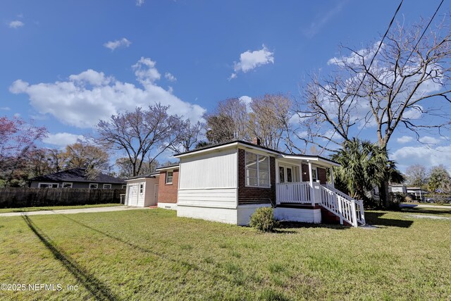 4804 Elizabeth Ter, Jacksonville, FL 32205 - view of home's exterior with concrete driveway, brick siding, a yard, and covered porch