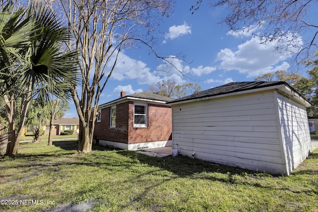 4804 Elizabeth Ter, Jacksonville, FL 32205 - view of side of home with brick siding, a lawn, and an outdoor structure