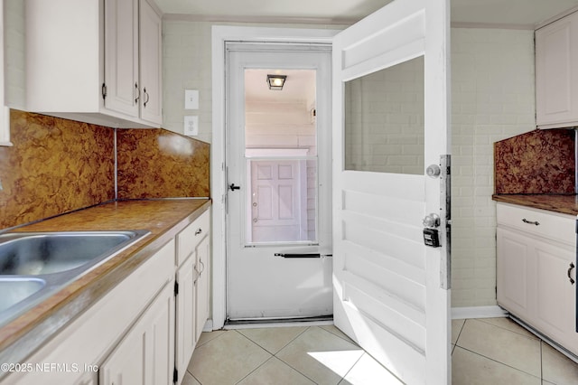 4804 Elizabeth Ter, Jacksonville, FL 32205 - kitchen featuring white cabinetry, decorative backsplash, and light tile patterned floors