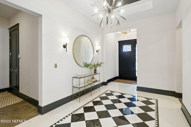 entryway featuring a chandelier and baseboards