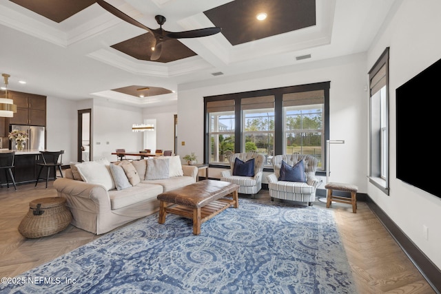 living area featuring visible vents, baseboards, coffered ceiling, and crown molding