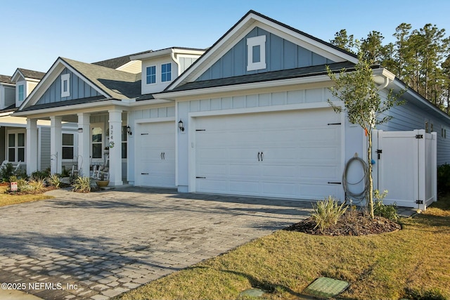 view of front of home featuring board and batten siding, decorative driveway, and an attached garage