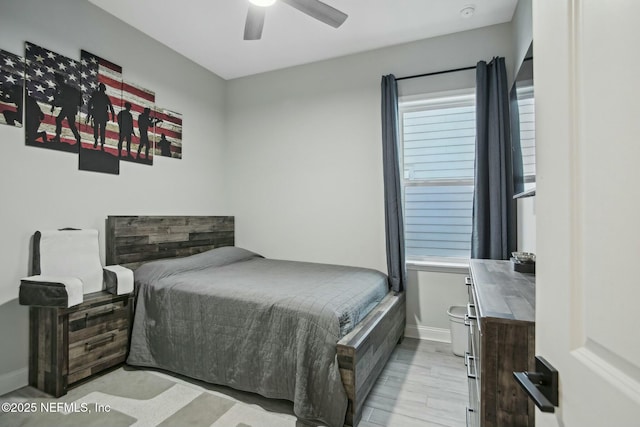 bedroom featuring ceiling fan, light wood finished floors, and baseboards