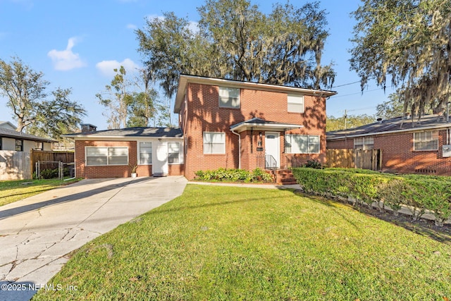 view of front of home with a front yard, brick siding, and fence