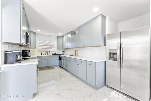 kitchen with marble finish floor, stainless steel appliances, and gray cabinets