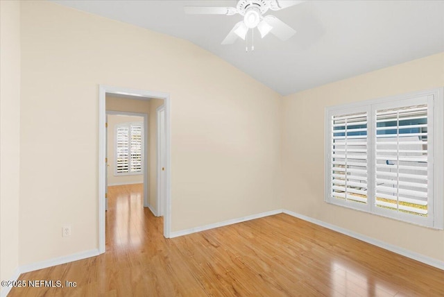 unfurnished room with light wood finished floors, ceiling fan, baseboards, and vaulted ceiling