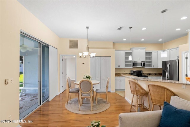 dining room with light wood-style flooring, visible vents, a notable chandelier, and recessed lighting