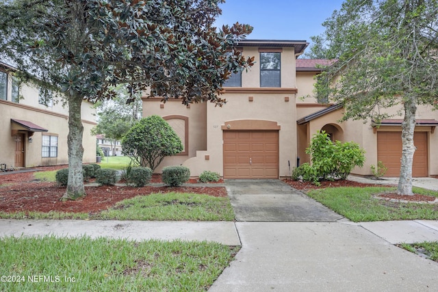 view of front of property with driveway, an attached garage, and stucco siding