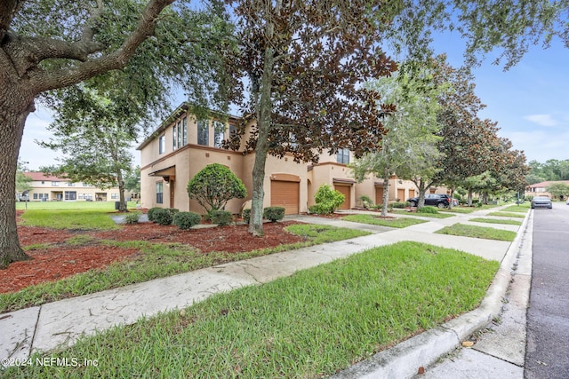 view of front of house with driveway, a front yard, and stucco siding