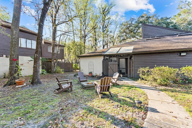 view of yard featuring an outdoor fire pit and fence