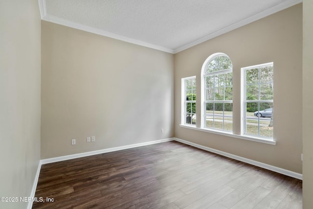 empty room featuring a wealth of natural light, crown molding, a textured ceiling, and dark wood-style flooring